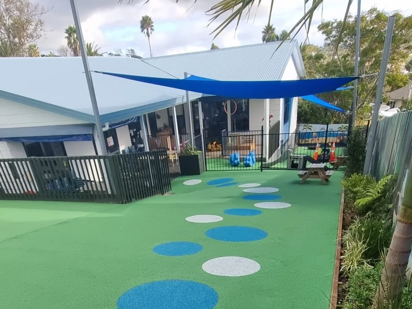 The upgraded outdoor playground at Growing Minds with soft surfacing, shade sails and planting
